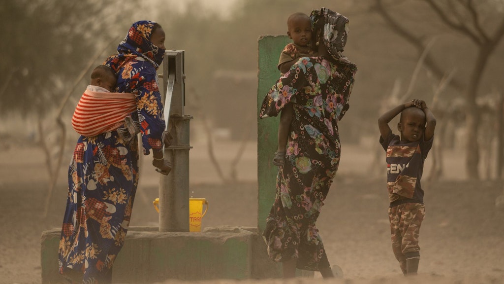 Afrikanische Frauen pumpen Wasser aus einem Brunnen im Tschad.