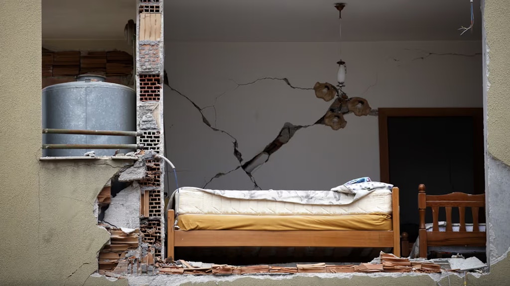 Das Erbeben riss ein Loch in die Fassade eines Wohngebäudes, in welchem ein Bett zu sehen ist.