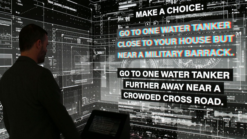 Ein Mann befindet sich vor einem Bildschirm, der eine digitale Umgebung simuliert.