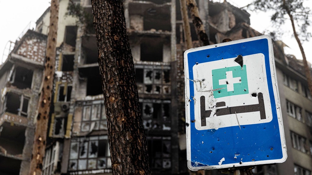 Zerstörte Gebäude und ein Schild, das auf ein Krankenhaus hinweist.