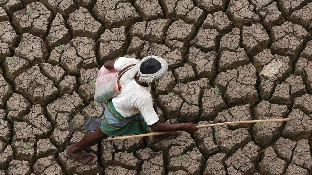 Ein Mann läuft über ein ausgetrocknetes Feld.