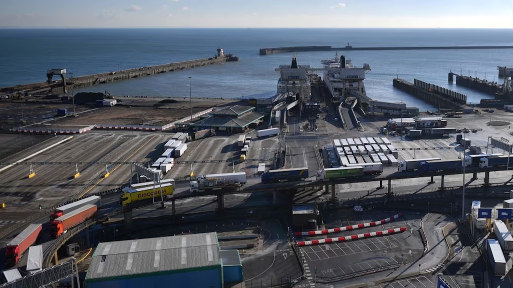 Lastwagen fahren in einer Zweierreihe auf einer Rampe von der Fähre ins Hafengebiet.