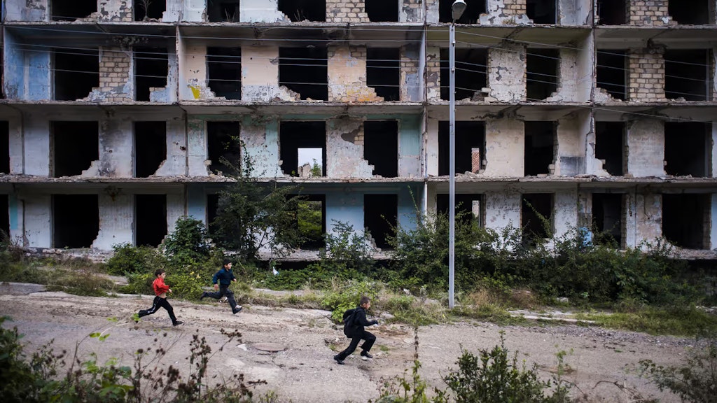 Nagorny-Karabach: Kinder laufen an einem im Krieg zerstörten Gebäude vorbei.