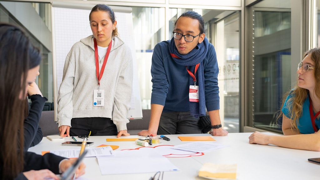  Junge Leute tauschen sich in einem Raum aus.