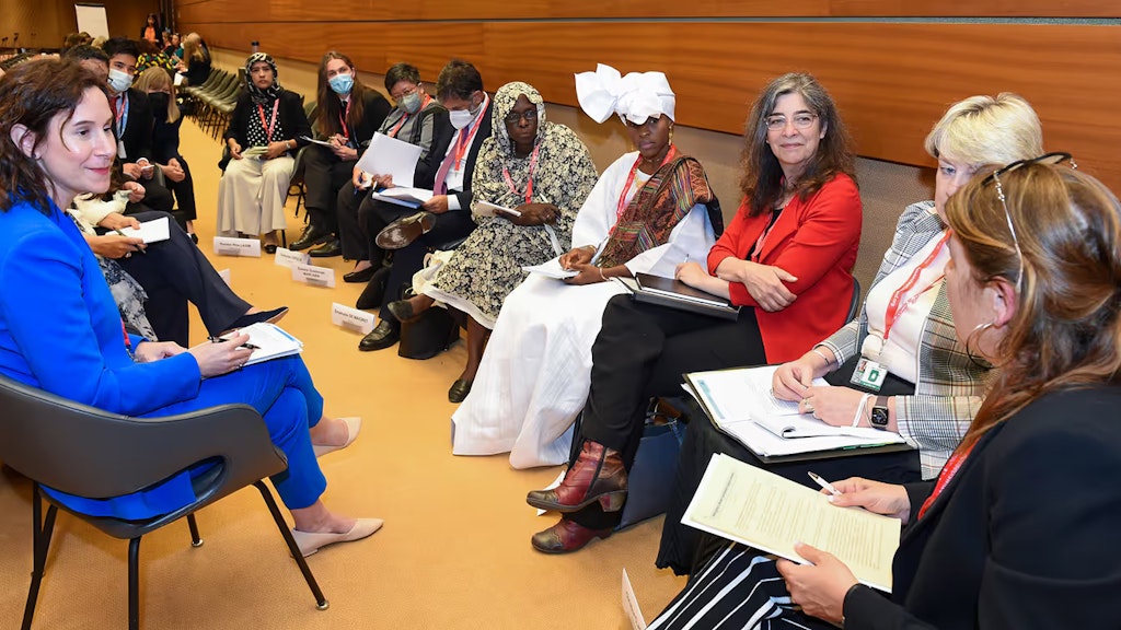 Eine Gruppe von Teilnehmenden des Genfer Treffens diskutiert im Kreis.