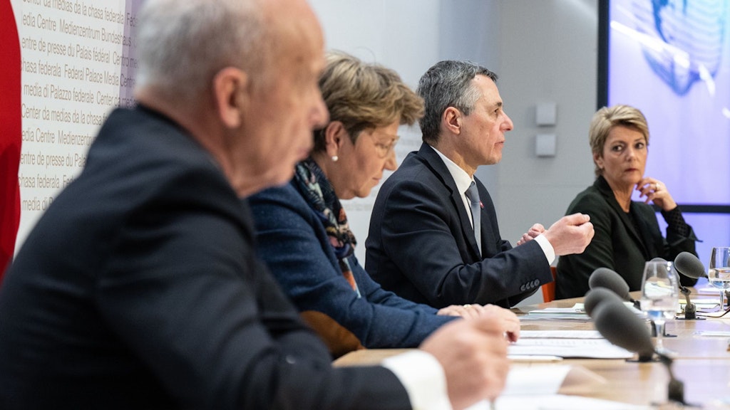 Vier Mitglieder des Bundesrates sitzen an einem grossen Pult. 