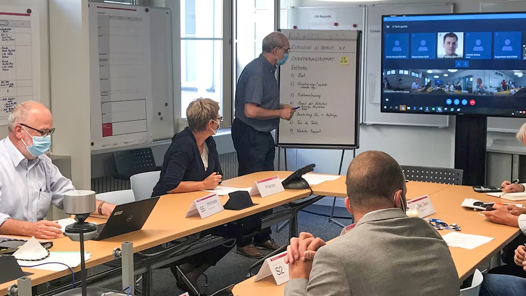 Mitglieder der Einsatzleitung der humanitären Hilfe des Bundes sitzen an einem Tisch besprechen den Einsatz in Beirut