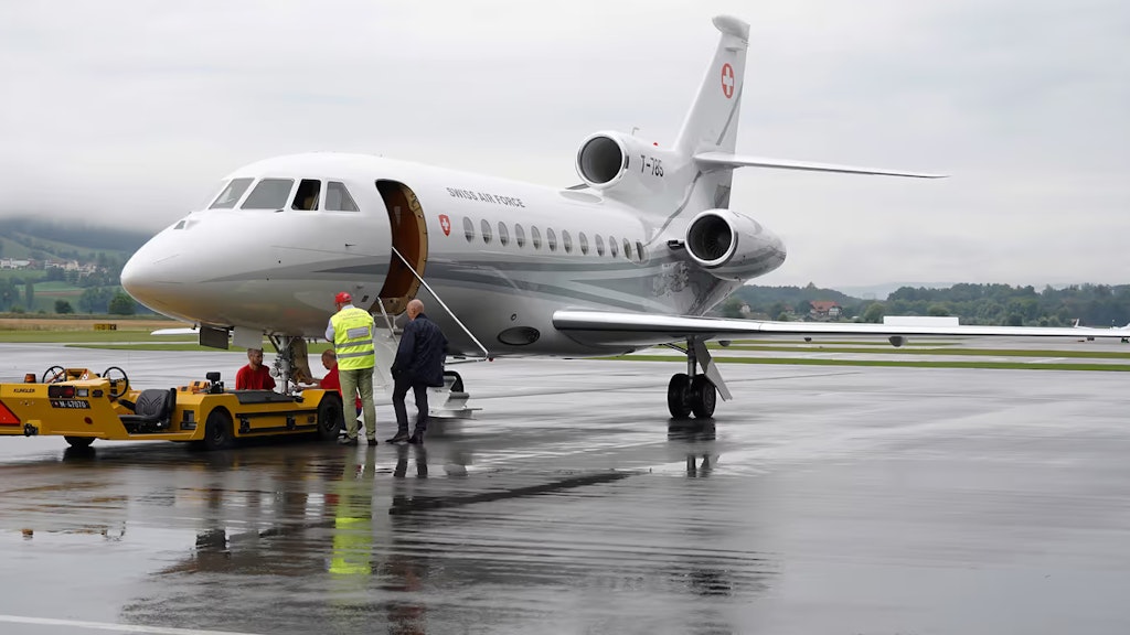 Zwei Männer stehen vor einem Jet auf dem Rollfeld des Flughafens Bern-Belp. 