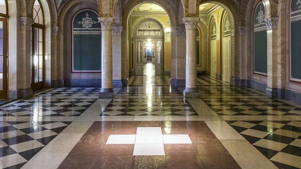 Blick in das Innere vom Bundeshaus West mit einem Schweizer Kreuz auf dem Boden. 