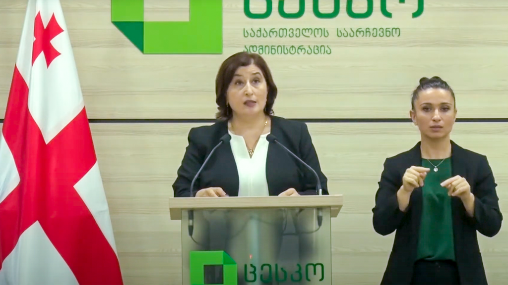 Die Leiterin der Zentralen Wahlkommission in Georgien steht am Pult, neben ihr eine Spezialistin für Gebärdensprache.