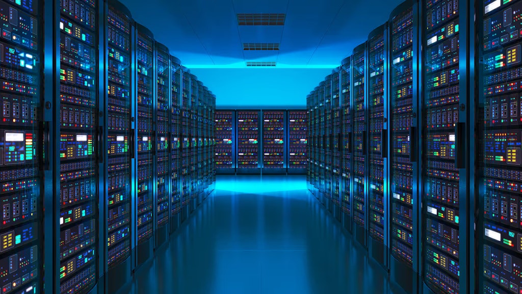 In einem dunklen, blau beleuchteten Raum stehen lange Reihen von Servern, in denen digitale Daten gespeichert sind.