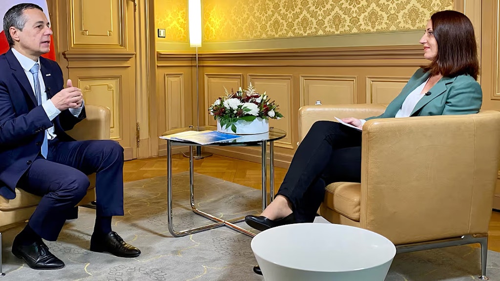 Bundesrat Ignazio Cassis sitzt in einem Stuhl und unterhält sich im Rahmen eines Interviews mit der Moderatorin. 