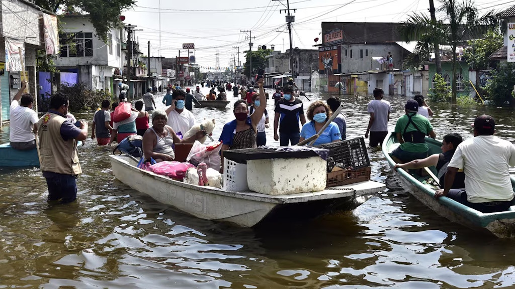 Anwohner überqueren eine von starken Regenfällen überschwemmte Allee nach dem Hurrikan Eta.