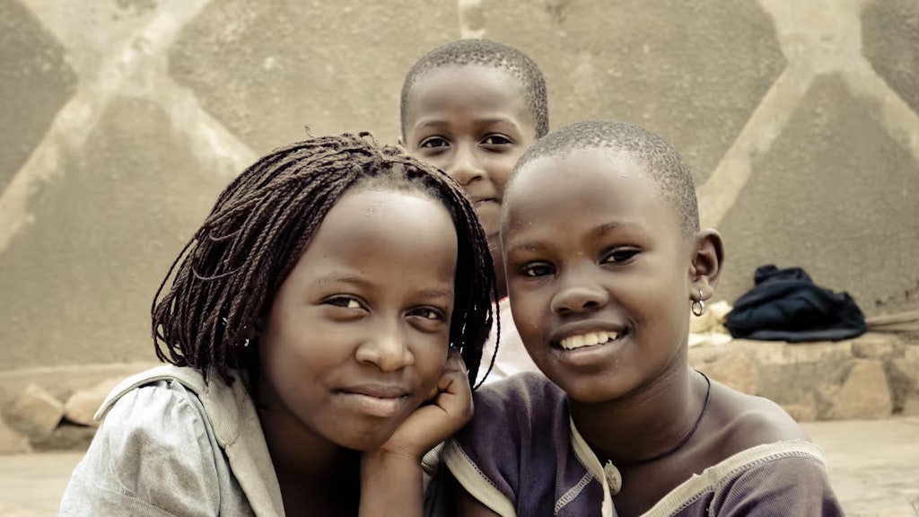 Drei Strassenkinder posieren in Kampala (Uganda) vor der Kamera.