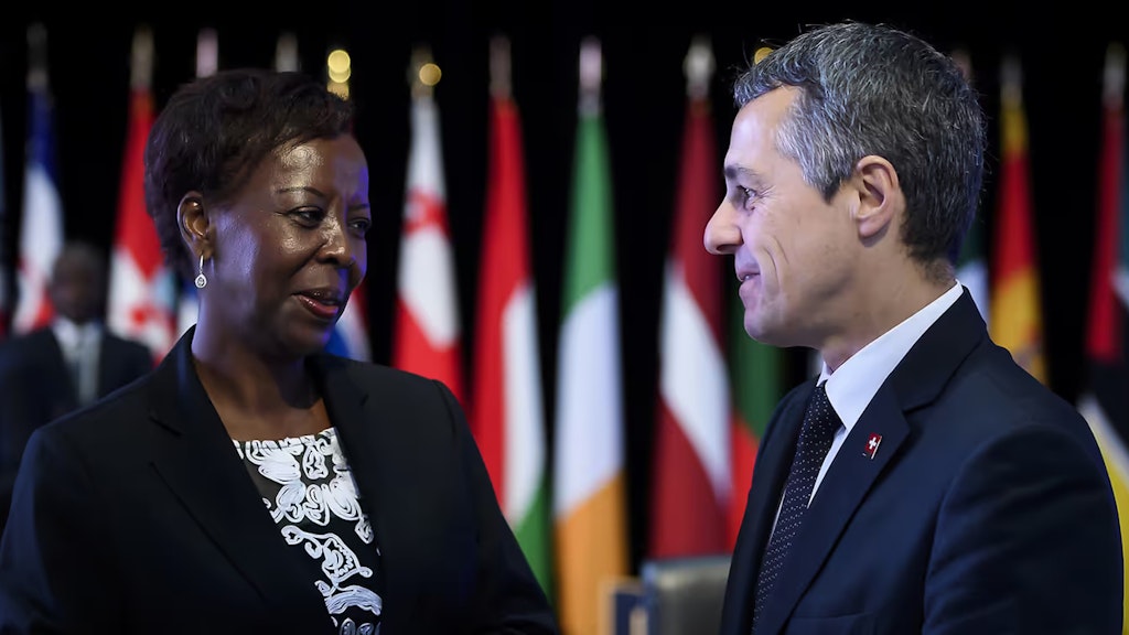 Ignazio Cassis und die Generalsekretärin der Frankophonie, Louise Mushikiwabo, im Gespräch. Im Hintergrund die Flaggen der 54 Mitgliedsstaaten und Regierungen.