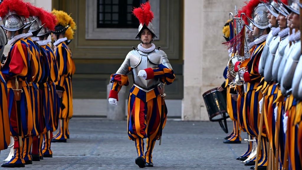 Ein Gardist marschiert an der Vereidigungsfeier. Zu seiner Linken und Rechten stehen die Kameraden Spalier.