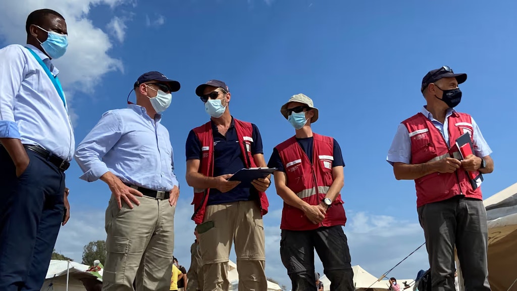 Der Chef der Humanitären Hilfe des Bundes, Manuel Bessler, unterhält sich bei einem Besuch vor Ort mit Experten des Schweizerischen Korps für humanitäre Hilfe und dem stellvertretenden Lagerleiter von Lesbos, Spiros Habimama.