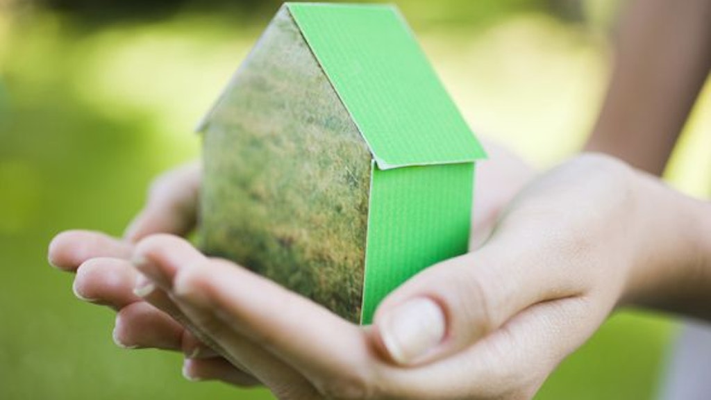 Due mani racchiudono una casetta verde di cartone.
