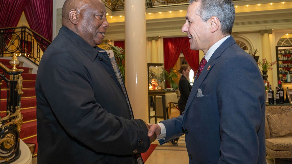 Zwei Männer begrüssen sich in einem festlichen Raum.