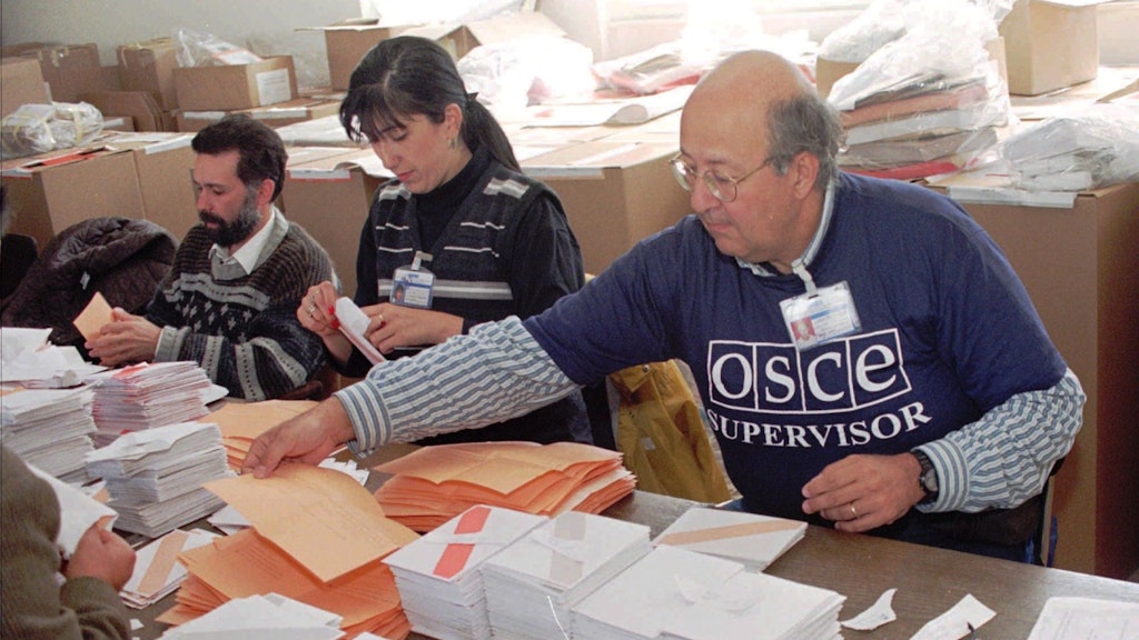 Ein OSZE-Beobachter sortiert und zählt 1996 in der Innenstadt von Sarajevo Wahlstimmen bei den Wahlen.