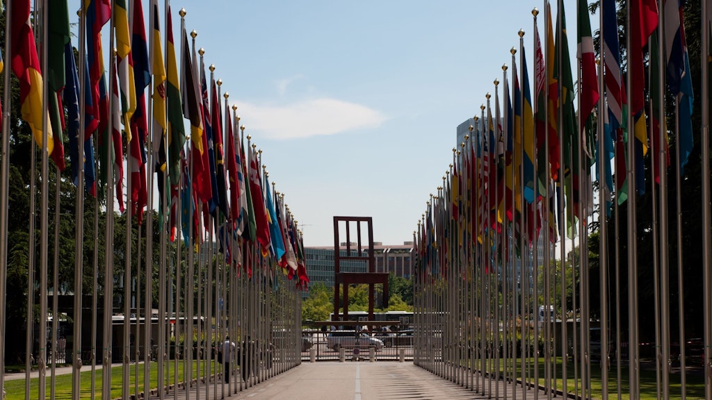 Flaggen der Vereinten Nationen vor dem «Broken Chair» auf der Place des Nations in Genf, Schweiz