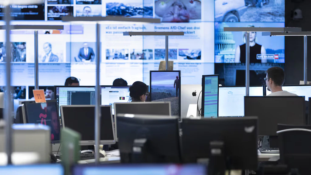 Die Redaktion einer Zeitung. Die Journalisten arbeiten vor Bildschirmen.