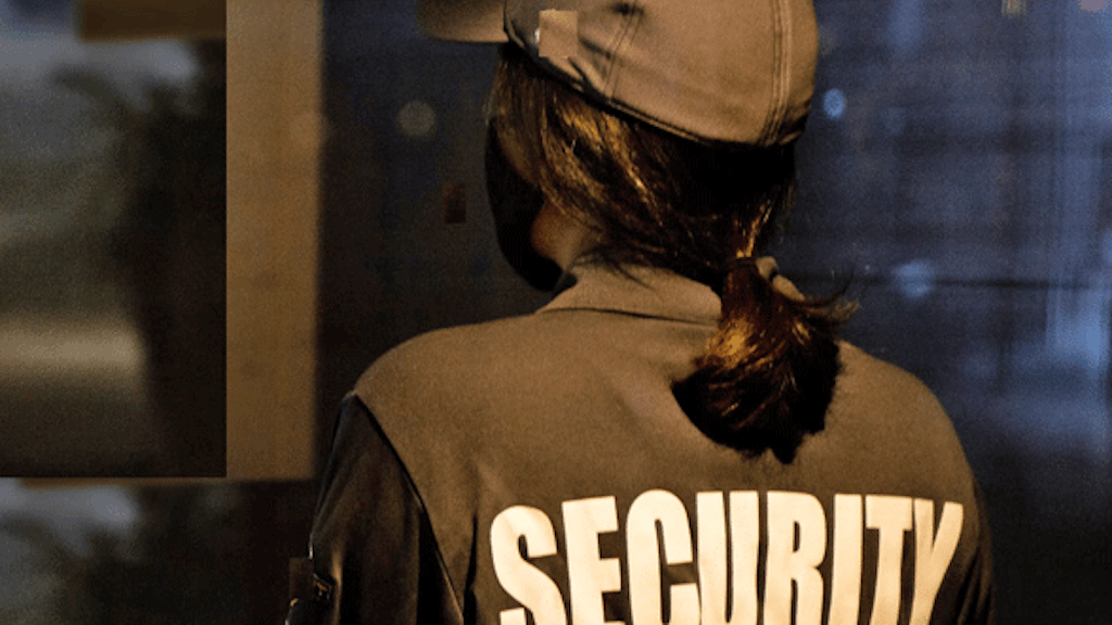 Eine Frau in Uniform, auf deren Rücken «Security» steht.