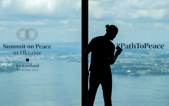 Ein Mann bringt das Logo der Konferenz an einem grossflächigen Fenster an. 