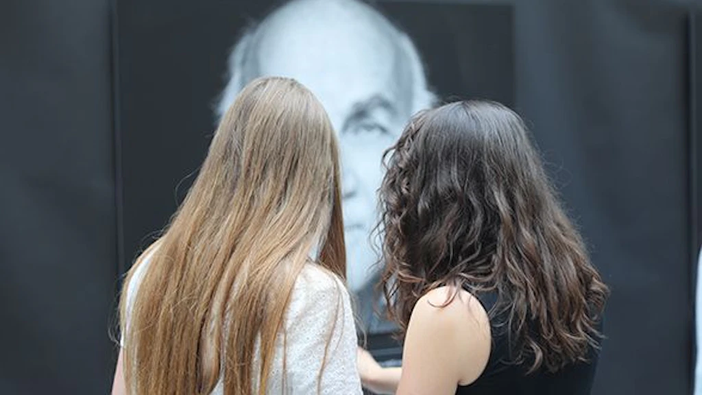 Zwei Schülerinnen betrachten ein Ausstellungsposter.