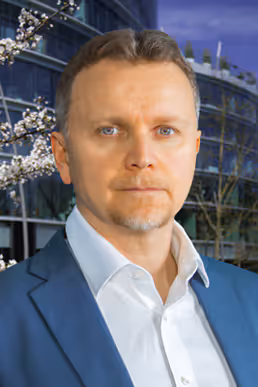 Paul Dziatkowiec, im Hintergrund ein modernes Gebäude.