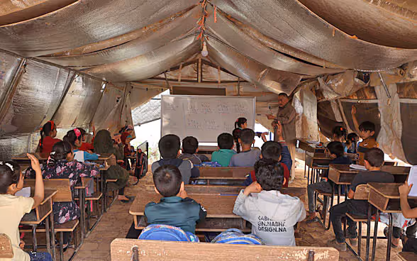 Syrische Kinder besuchen den Unterricht in einer behelfsmässigen Schule in einem Lager für Binnenvertriebene.