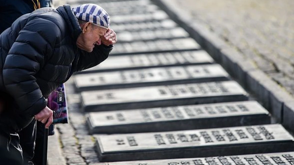 Holocaust Überlebender schaut auf Gedenktafeln von Opfern.