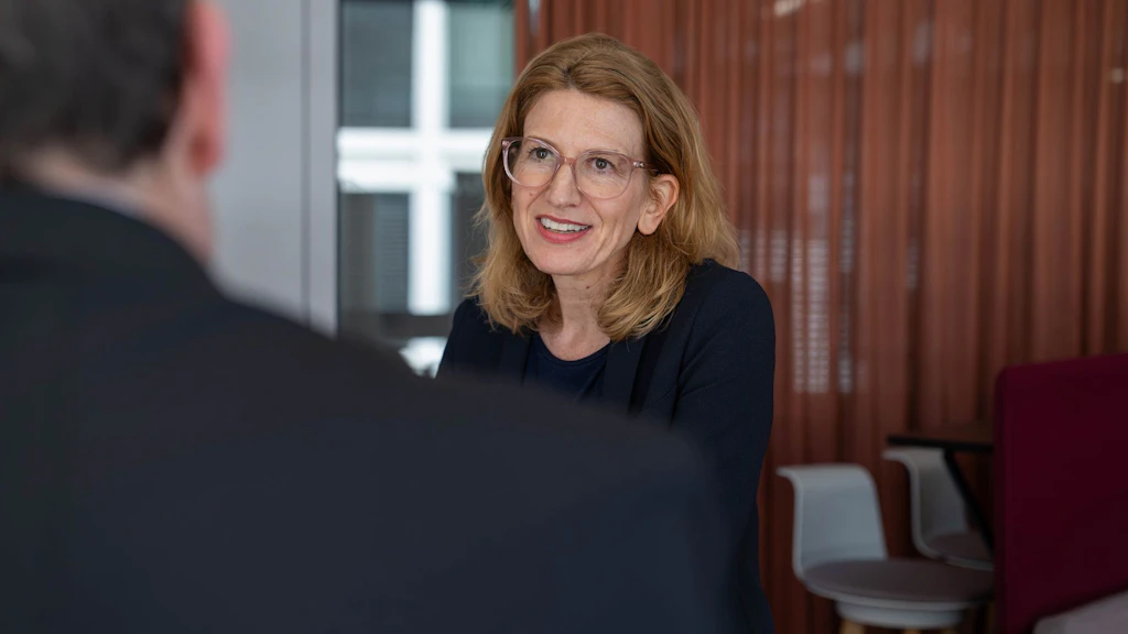Valérie Liechti sitzt an einem Tisch und spricht. 