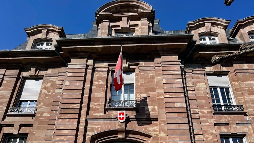 Gebäude der Schweizer Vertretung beim Europarat in Strassburg, aus Sandstein mit Schweizer Flagge und Wappen über dem Eingang. 