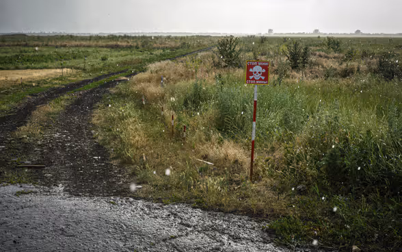Eine Tafel warnt vor einem Minenfeld in der Ukraine.