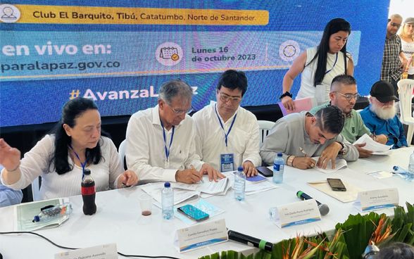Vertreter der kolumbianischen Regierung und der EMC FARC-EP unterzeichnen ein Dokument.