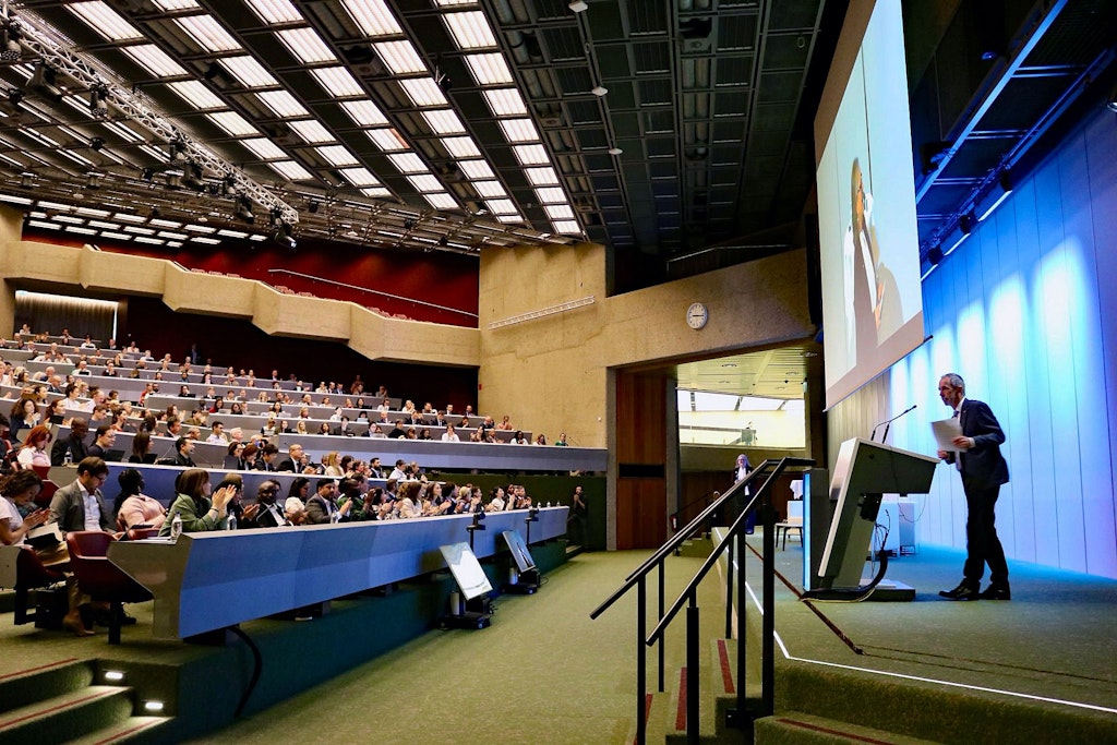 Dominik Stillhart spricht vor einem vollbesetzten Saal.  