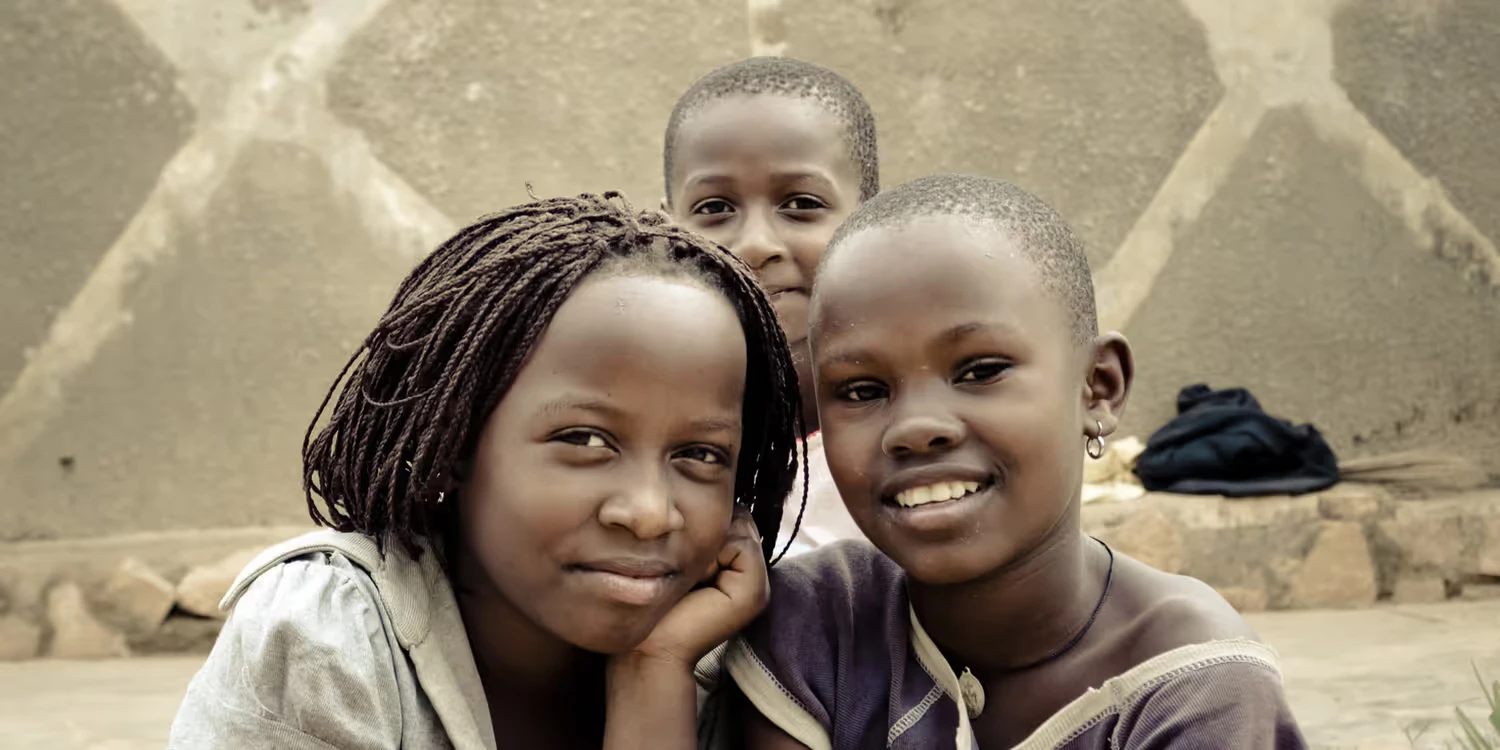 Drei Strassenkinder posieren in Kampala (Uganda) vor der Kamera.