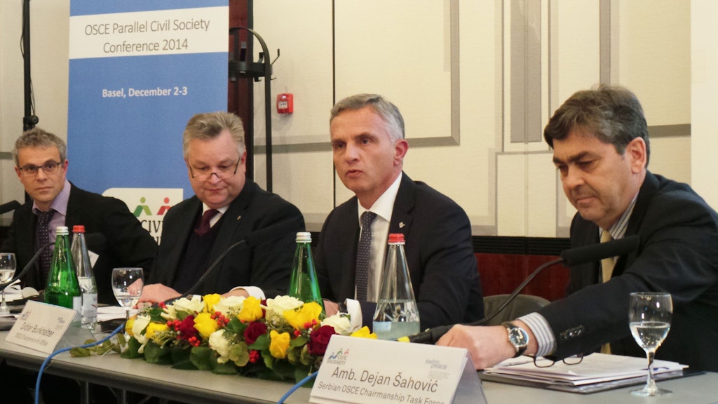 Bundespräsident bei seinem Statement anlässlich der OSZE-Parallelkonferenz der Zivilgesellschaft am 3. Dezember 2014 in Basel. Rechts neben ihm Dejan Sahovic, Chef der serbischen OSZE-Task Force, links Michael Link, Direktor des OSZE-Büros für demokratische Institutionen und Menschenrechte (ODIHR), und Laurent Goetschel (ganz links), Direktor der Organisation Swisspeace.