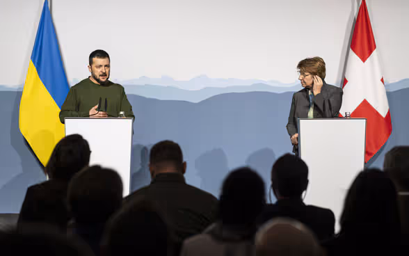 President Viola Amherd stands at a lectern to the right of President Volodymyr Zelenskyy.