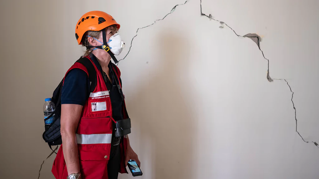 Engineer Regina Wenk examines a damaged wall for its stability.
