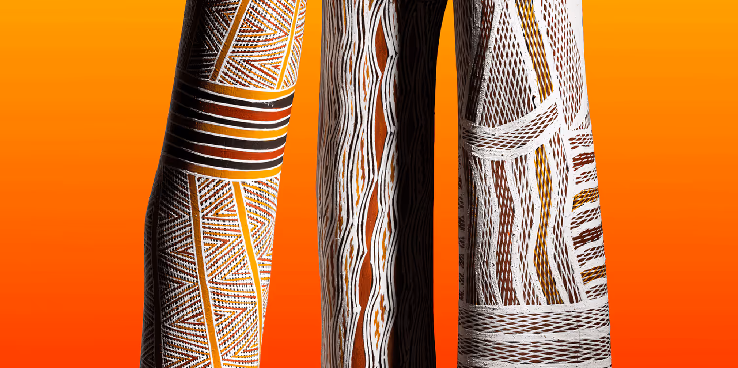 alt="Three brightly painted yidakis shown against a yellow background, with the words 'Breath of Life' superimposed on them."