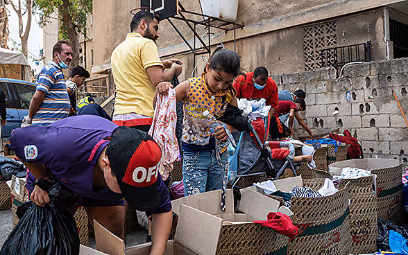 Residents dig through boxes of donated clothes. 