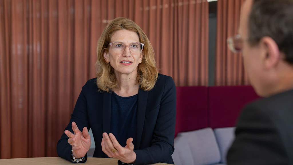 Valérie Liechti sits at a table and speaks. 