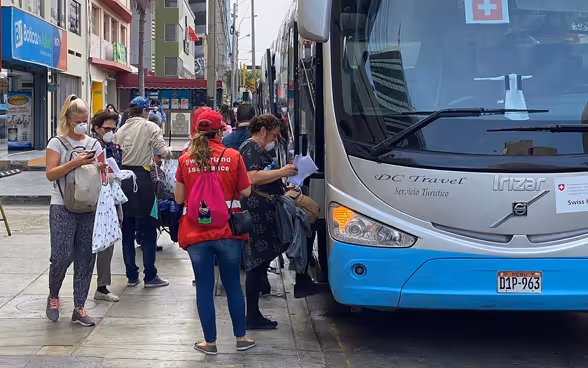 Several tourists board a bus organised by the Swiss Embassy. It takes them to Lima.