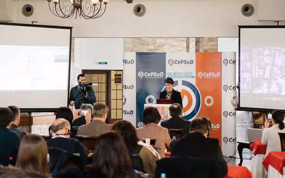 In a room, some people attend a presentation.