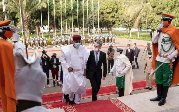 President Cassis and the Nigerien President Bazoum walk up a flight of stairs.