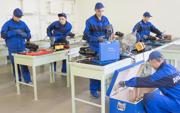 Five trainees working in a vocational school workshop in Ukraine.