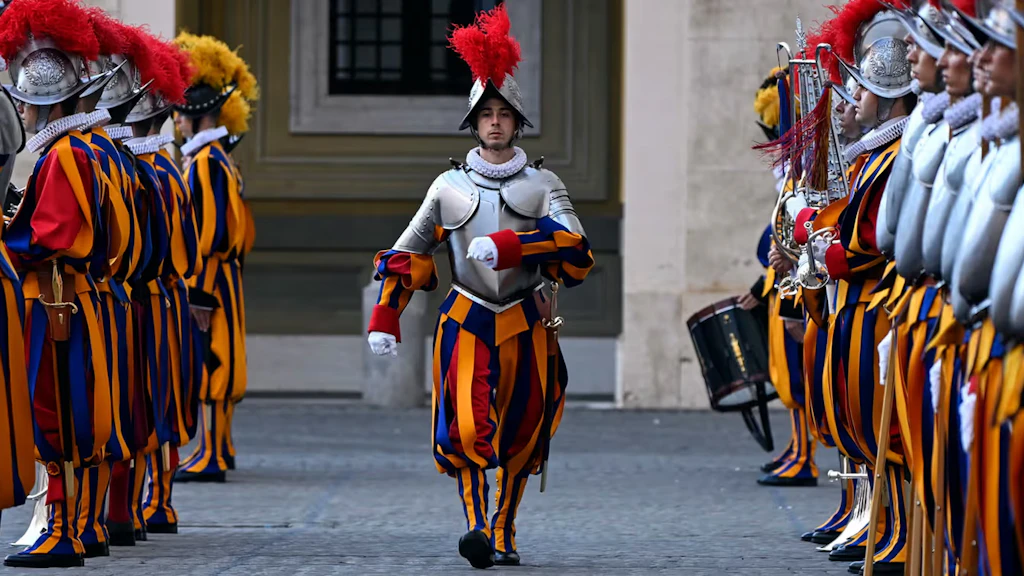 A guard marches during the swearing-in ceremony, his fellow soldiers lined up on either side of him.