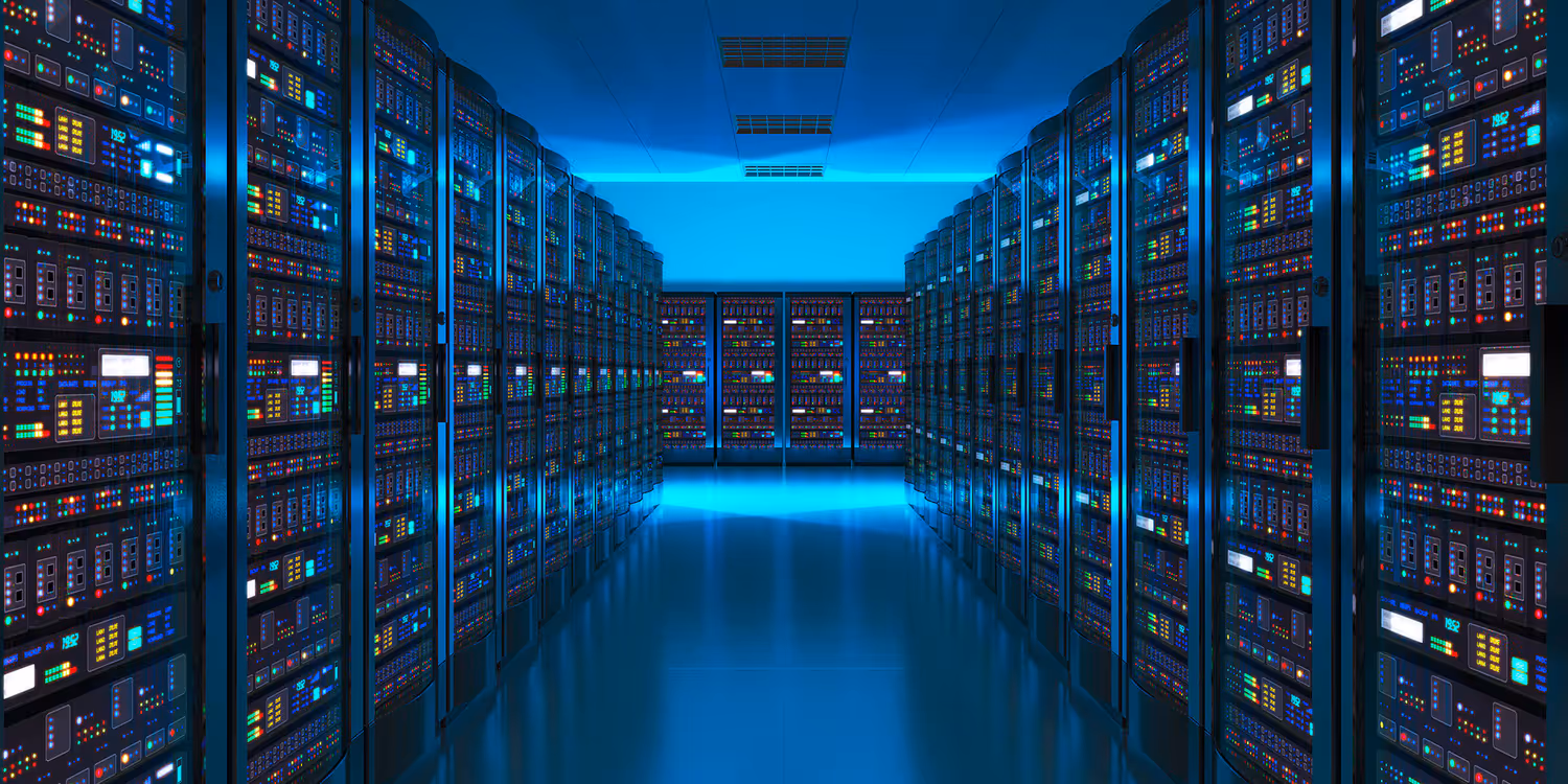 We see a darkened room with a blue glow containing rows of servers on which digital data is stored.